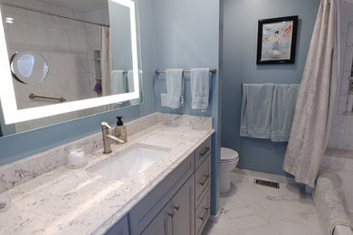 Example of a small transitional master white tile and ceramic tile ceramic tile and white floor bathroom design in St Louis with recessed-panel cabinets, gray cabinets, a one-piece toilet, blue walls, an undermount sink and quartz countertops