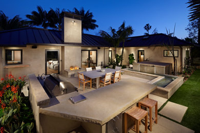 Modelo de patio contemporáneo grande sin cubierta en patio trasero con cocina exterior y adoquines de piedra natural