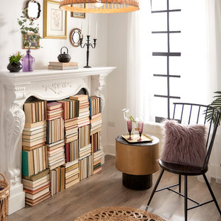 Idéer för små eklektiska arbetsrum, med ett bibliotek, vita väggar, ljust trägolv, en standard öppen spis, en spiselkrans i gips och brunt golv