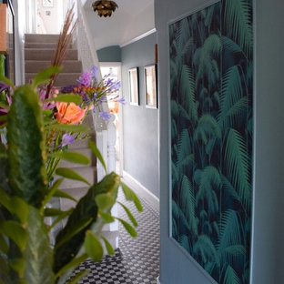 Foto på en liten eklektisk hall, med blå väggar, klinkergolv i keramik och svart golv