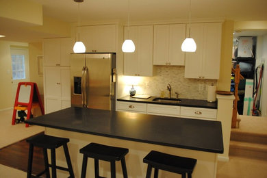Example of a mid-sized dark wood floor eat-in kitchen design in DC Metro with white cabinets, ceramic backsplash and an island