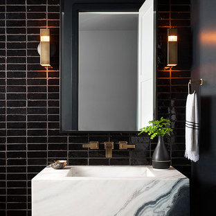 Immagine di un bagno di servizio minimalista con piastrelle nere, piastrelle in terracotta, lavabo integrato e top bianco