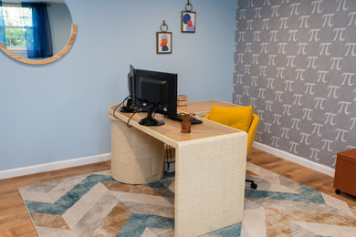 Mid-century modern freestanding desk vinyl floor and wallpaper home office photo in Philadelphia with blue walls