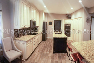Large elegant galley vinyl floor and brown floor eat-in kitchen photo in Kansas City with an undermount sink, raised-panel cabinets, white cabinets, granite countertops, multicolored backsplash, mosaic tile backsplash, stainless steel appliances and two islands