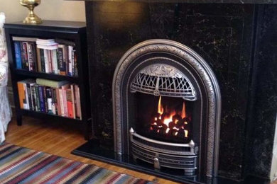 Inspiration for a timeless family room remodel in New York with a standard fireplace and a stone fireplace