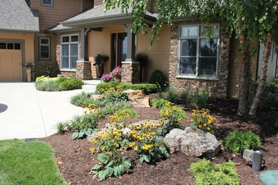 This is an example of a mid-sized traditional partial sun front yard mulch landscaping in Other.