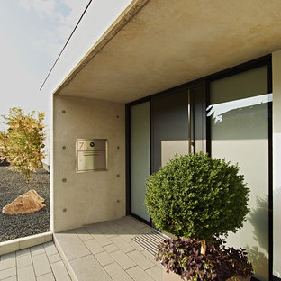 Idee per un ingresso o corridoio minimal con una porta singola, una porta grigia e pareti grigie