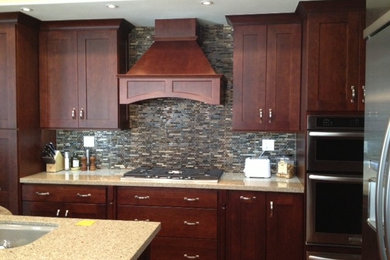 Mid-sized elegant u-shaped dark wood floor eat-in kitchen photo in Orange County with shaker cabinets, granite countertops, gray backsplash, matchstick tile backsplash, stainless steel appliances, an island, a single-bowl sink and dark wood cabinets