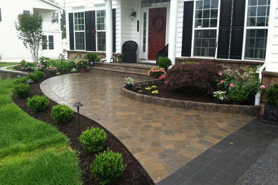 Photo of a mid-sized traditional front yard driveway in Wilmington with a garden path and brick pavers.