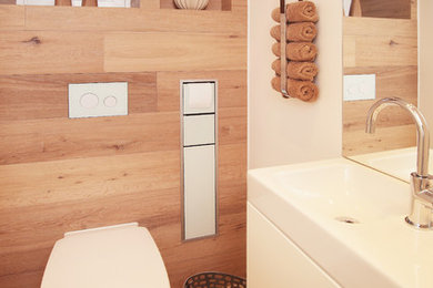 Kleine Moderne Gästetoilette mit flächenbündigen Schrankfronten, weißen Schränken, Wandtoilette, beiger Wandfarbe, Keramikboden, Aufsatzwaschbecken und beigem Boden in Sonstige