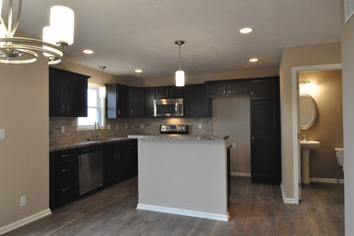 Kitchen - transitional kitchen idea in Other with an undermount sink, dark wood cabinets, laminate countertops, beige backsplash, porcelain backsplash and black appliances