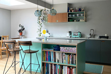 This is an example of a modern kitchen in Surrey with recycled glass countertops and turquoise worktops.