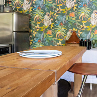 Design ideas for a mid-sized tropical open plan dining in Paris with white walls, laminate floors and beige floor.