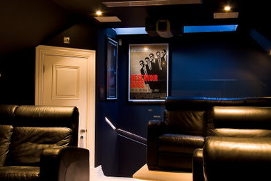 Ejemplo de cine en casa cerrado minimalista de tamaño medio con paredes negras, moqueta, pantalla de proyección y suelo beige