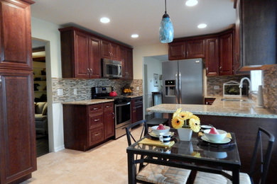 Mid-sized transitional galley medium tone wood floor and beige floor eat-in kitchen photo in Chicago with an undermount sink, raised-panel cabinets, medium tone wood cabinets, granite countertops, gray backsplash, glass sheet backsplash, stainless steel appliances and a peninsula