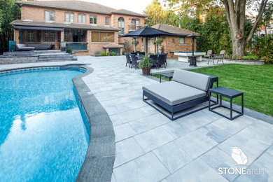 Diseño de piscina a medida en patio trasero con adoquines de piedra natural