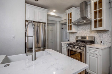 Eat-in kitchen - modern medium tone wood floor and brown floor eat-in kitchen idea in Kansas City with a farmhouse sink, white cabinets, stainless steel appliances, an island, marble countertops, gray backsplash, ceramic backsplash and white countertops