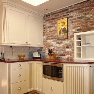 Modelo de cocina ecléctica con puertas de armario beige y encimeras rojas