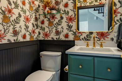 Example of a small transitional wood-look tile white floor, ceramic tile and wallpaper powder room design in Columbus with a two-piece toilet, white walls, an undermount sink, quartz countertops, white countertops, a built-in vanity, flat-panel cabinets and green cabinets
