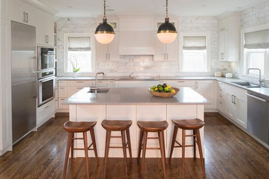 Inspiration for a large contemporary l-shaped medium tone wood floor and brown floor kitchen remodel in Other with an undermount sink, flat-panel cabinets, white cabinets, quartz countertops, gray backsplash, marble backsplash, stainless steel appliances and an island