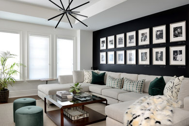 Mid-sized transitional open concept family room in Toronto with black walls, carpet, a wall-mounted tv and beige floor.