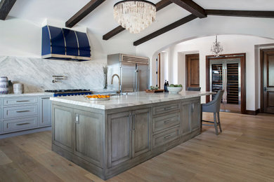 Transitional kitchen photo in Orange County with shaker cabinets, gray cabinets, white backsplash and an island
