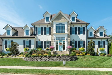 Example of a large classic white two-story brick house exterior design in Nashville with a hip roof and a shingle roof