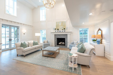 Living room - huge traditional formal and loft-style light wood floor, coffered ceiling and wall paneling living room idea in Oklahoma City with white walls, a standard fireplace, a stone fireplace and no tv