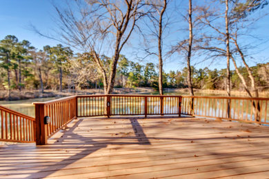 Example of a large classic backyard ground level wood railing dock design in Houston with no cover