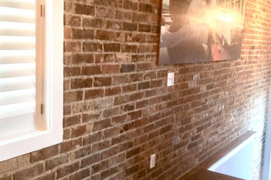 ナッシュビルにある低価格の広いラスティックスタイルのおしゃれなダイニングキッチン (茶色い壁、濃色無垢フローリング、両方向型暖炉、レンガの暖炉まわり、茶色い床、三角天井、レンガ壁) の写真