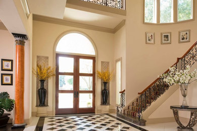 Entryway - huge traditional marble floor entryway idea in Dallas with beige walls and a glass front door