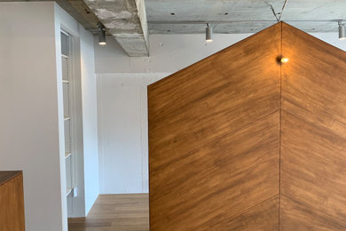 Diseño de salón abierto y gris de tamaño medio con suelo de madera pintada, suelo marrón y vigas vistas