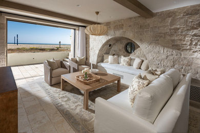Tuscan beige floor and exposed beam living room photo in Orange County with beige walls