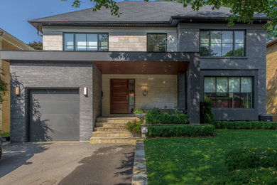 Example of a mid-sized trendy gray two-story brick exterior home design in Toronto with a shed roof