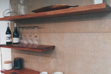 Modelo de cocina actual con armarios estilo shaker, puertas de armario negras, encimera de azulejos, salpicadero de azulejos de cemento, suelo de baldosas de porcelana, suelo blanco y barras de cocina