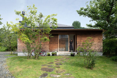 Diseño de fachada de casa marrón y gris minimalista de tamaño medio de una planta con revestimiento de madera, tejado de metal y tablilla