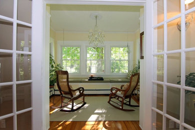 This is an example of a mid-sized traditional sunroom in Milwaukee with medium hardwood floors, no fireplace and a standard ceiling.