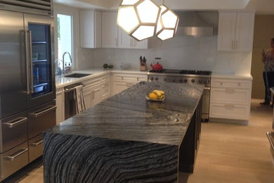 Example of a large transitional u-shaped kitchen design in Miami with a single-bowl sink, flat-panel cabinets, white cabinets, marble countertops, white backsplash, stainless steel appliances and an island
