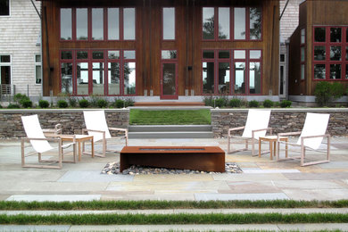 Inspiration for a large contemporary backyard stone patio remodel in Providence with a fire pit