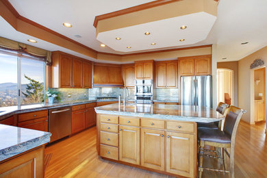 Inspiration for a large u-shaped light wood floor and beige floor open concept kitchen remodel in Houston with an undermount sink, raised-panel cabinets, light wood cabinets, granite countertops, stone slab backsplash, stainless steel appliances and an island