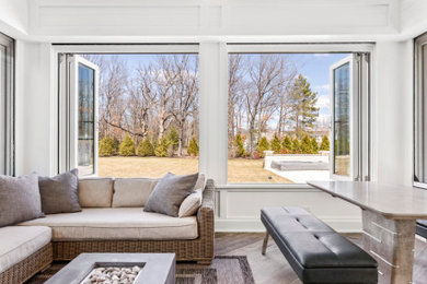 Design ideas for a mid-sized sunroom in Chicago with a two-sided fireplace and a concrete fireplace surround.