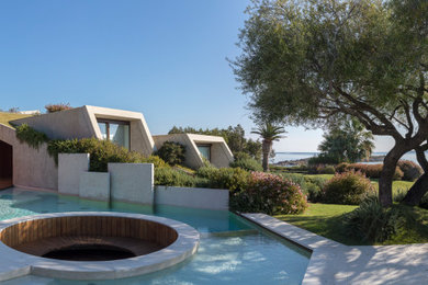 Design ideas for an expansive modern front yard custom-shaped pool in Cagliari with a hot tub and natural stone pavers.