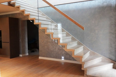 Пример оригинального дизайна: прямая лестница среднего размера в современном стиле с деревянными ступенями и стеклянными перилами