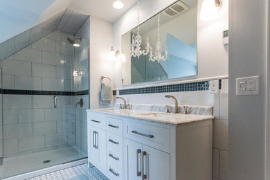 Example of a mid-sized trendy master white tile and ceramic tile ceramic tile alcove shower design in Minneapolis with shaker cabinets, white cabinets, a two-piece toilet, white walls, a drop-in sink and marble countertops