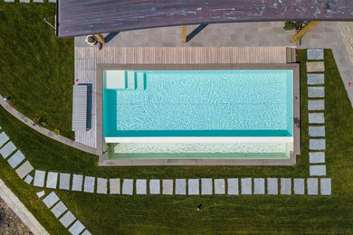 Foto di una piscina a sfioro infinito minimalista rettangolare davanti casa e di medie dimensioni