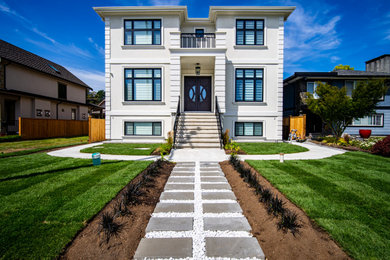 Example of a classic white three-story stucco house exterior design in Vancouver with a shingle roof and a black roof