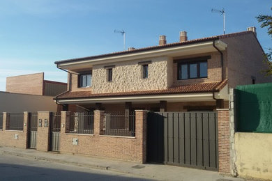 Ejemplo de fachada de casa pareada clásica renovada grande de dos plantas con revestimientos combinados, tejado a dos aguas y tejado de teja de barro