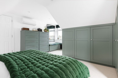Medium sized modern master bedroom in Hertfordshire with white walls, carpet, beige floors and a vaulted ceiling.