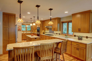 Transitional medium tone wood floor kitchen photo in Minneapolis with flat-panel cabinets, medium tone wood cabinets, granite countertops, beige backsplash, subway tile backsplash, stainless steel appliances and two islands