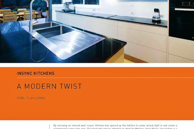 Moderne Wohnküche in L-Form mit Triple-Waschtisch, Glasfronten, grauen Schränken, Mineralwerkstoff-Arbeitsplatte, Küchenrückwand in Weiß, Glasrückwand, Küchengeräten aus Edelstahl, Bambusparkett und Kücheninsel in Brisbane